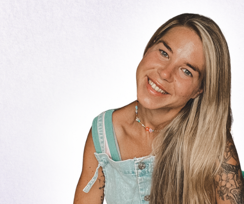 Claudia Ruppel Resilienz Coach Frauen -Online- Main Kinzig Kreis Junge Frau mit langen, blonden Haaren, die lächelt und ihre Hände vor dem Herzen hält- Claudia Ruppel Resilienz Coach